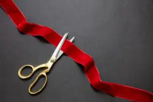 scissors cutting ribbon at grand opening