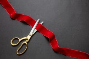 scissors cutting ribbon at grand opening